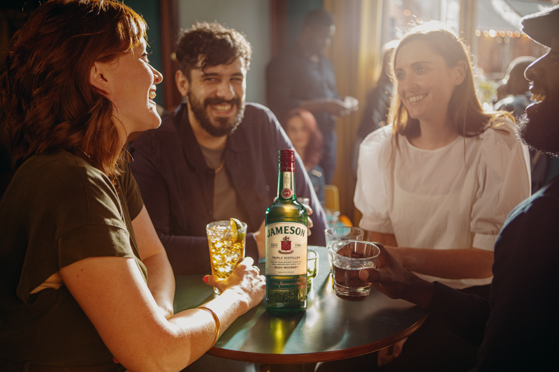 jameson irish whiskey being enjoyed by friends in a pub